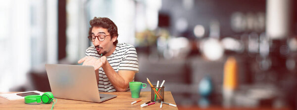 young bearded graphic designer with a laptop sending a flying true love kiss, showing care, fondness and affection; a sincere Saint Valentine's message.