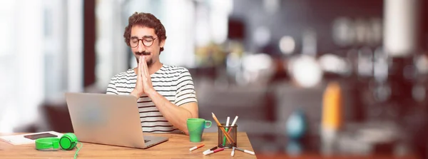 年轻胡子的平面设计师与膝上型电脑祈祷圣洁的方式 一个愿望发生 — 图库照片