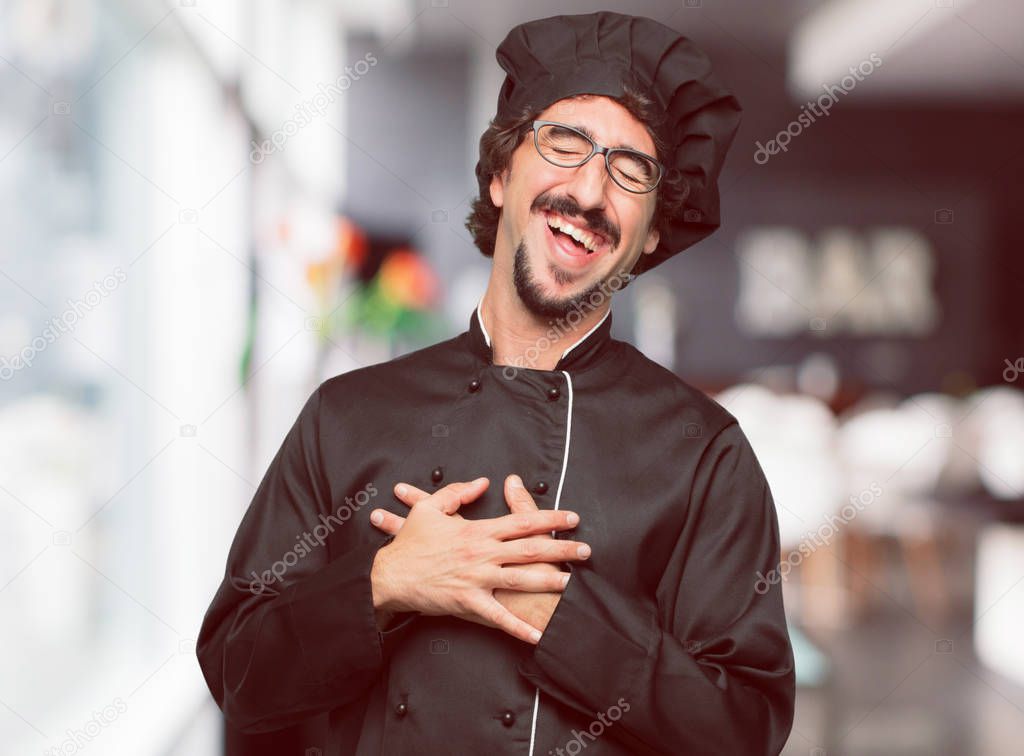 young crazy man as a chef Laughing out loud with head tilted backwards and happy, cheerful expression