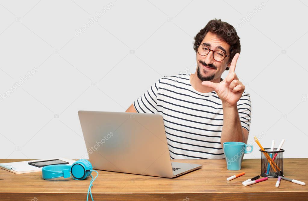 young bearded graphic designer with a laptop gesturing 