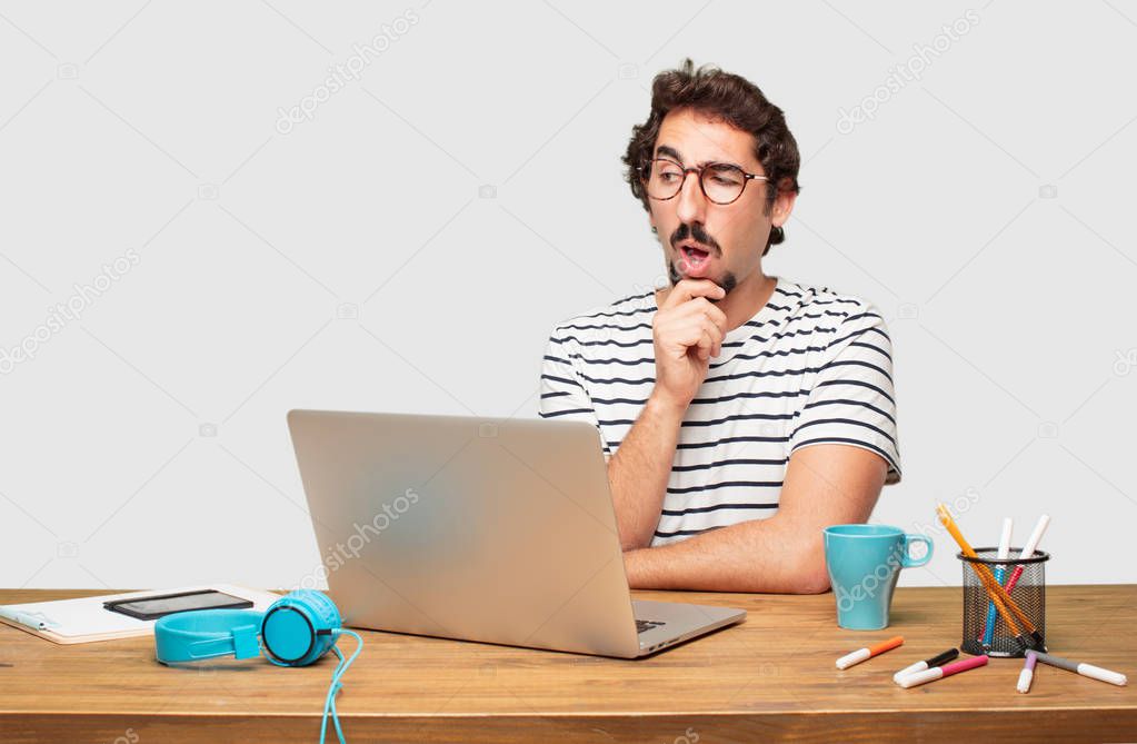 young bearded graphic designer with a laptop with a goofy, dumb, silly look, feeling shocked and confused at a recent realization, not really understanding an idea.