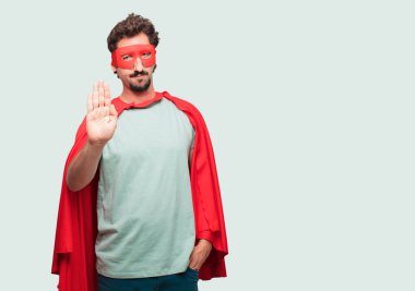 deli adam ileri, ciddi ve sert bir ifade ile karşı karşıya avucunun ile bir süper kahraman sinyal son olarak yasaklayan.