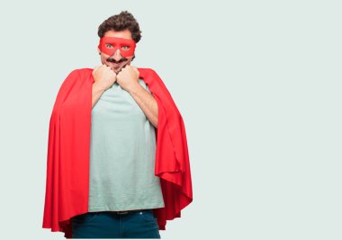 deli adam mutlu bir sürpriz ifade ile bir süper kahraman olarak gözleri geniş açık ve her iki el ile geniş gülümseme şok gösterilen çene altında sıktı.