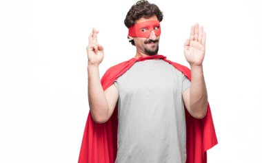 Genç süper kahraman güvenle gülümseyen bir samimi söz ver yoksa yemin, yaparken tek eliyle kalp üzerinde ciddiyetle küfür sakallı.