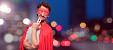 Gurur, kendinden emin ve mutlu bir görünüm, gülümseyen ve duygu memnun, yanal veya yan görünüm süper kahraman genç sakallı.