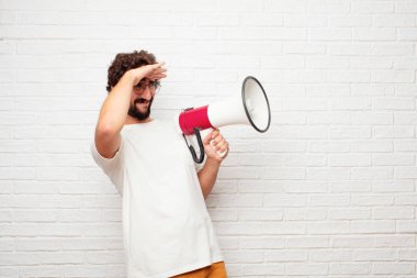 şaşkın bir bakışla uzak bir nesne için arama mesafe içine uzakta görünen genç aptal adam.