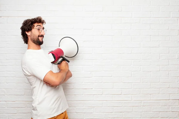 young dumb man standing sideways, with a proud, satisfied and happy look on face, smiling with arms crossed. Side or lateral view.