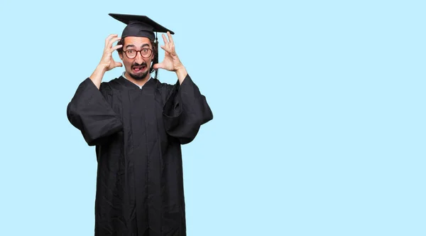 Young Graduated Man Shouting Crazy Amazed Look Surprise Holding Head — Stock Photo, Image