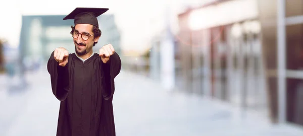 Junger Mann Mit Hochschulabschluss Lächelt Glücklich Und Zeigt Nach Vorne — Stockfoto