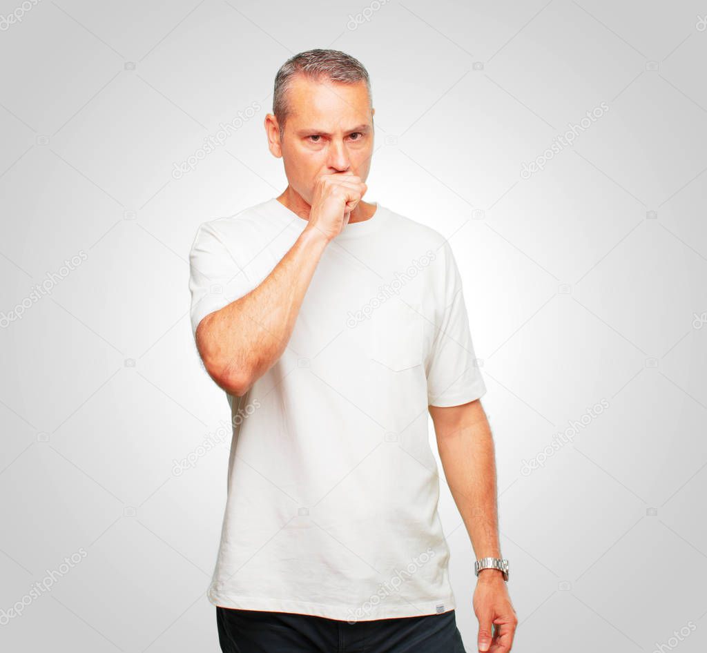 senior handsome man Coughing, suffering a winter illness such as a cold or the flu, feeling unwell and feverish.