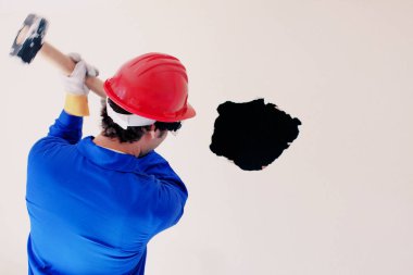 Kırmızı koruma kask ve mavi bir kazan takım elbise giyen genç bir işçi. Yıkım kavramı.