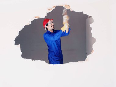 Kırmızı koruma kask ve mavi bir kazan takım elbise giyen genç bir işçi. Yıkım kavramı.