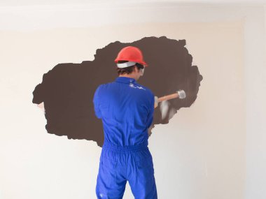 Kırmızı koruma kask ve mavi bir kazan takım elbise giyen genç bir işçi. Yıkım kavramı.