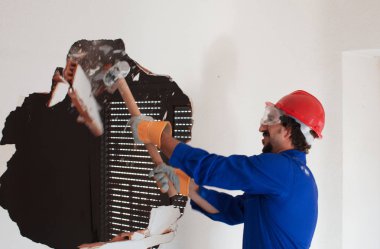 Kırmızı koruma kask ve mavi bir kazan takım elbise giyen genç bir işçi. Yıkım kavramı.