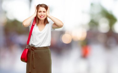 Genç kadın onları rahatsız, gürültülü, rahatsız edici bir gürültü korumak için kulaklar kapsayan iki eliyle güzel.