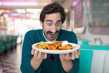 bir Amerikan akşam yemeği restoranda cips ile genç serin adam