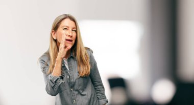 öne eğilerek ve bir sır ile ciddi bir ve sürpriz fısıldayarak güzel kadın kıdemli yüzünde bak