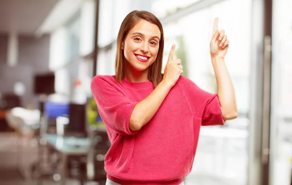 young woman full body. smiling and pointing upwards with both hands, towards the place where the publicist may show a concept.