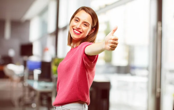 young woman full body. with a satisfied, proud and happy look with thumbs up, signalining OK with one hand, sending a positive, \