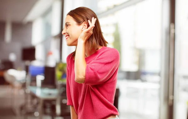 young woman full body. paying attention, trying to hear and listen to what is being said, lending an ear.