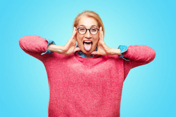 Взрослая блондинка шутит, торчит языком со смешным, глупым и игривым выражением лица, похожим на дурака
.