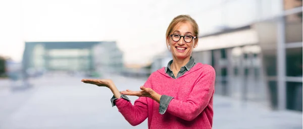 Schöne Erwachsene Blonde Frau Mit Zufriedenem Gesichtsausdruck Die Ein Objekt — Stockfoto