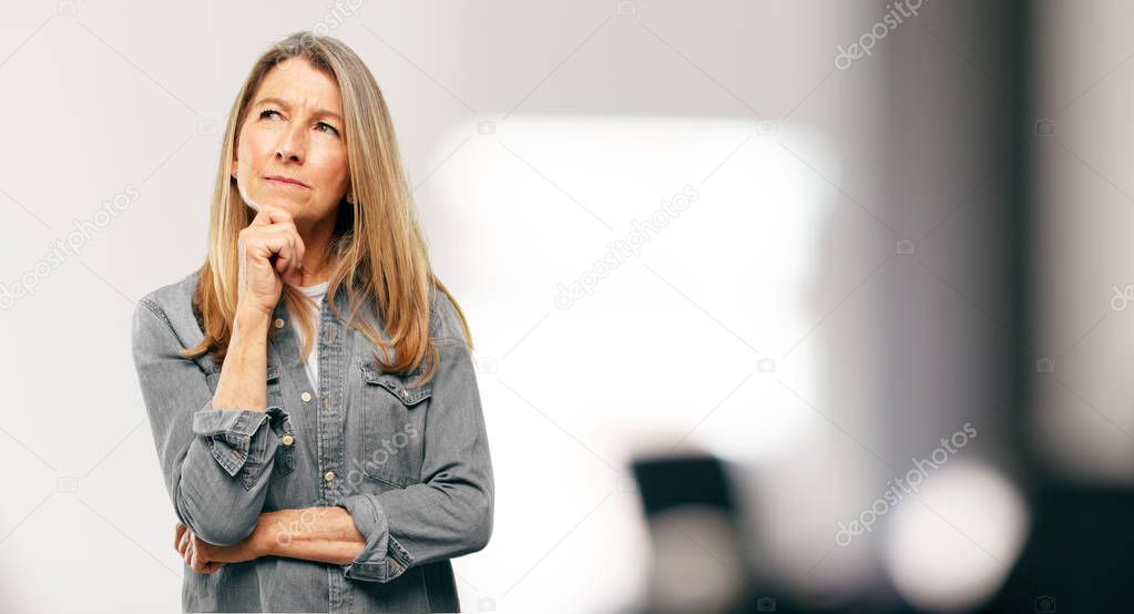 senior beautiful woman With a confused and thoughtful look, looking sideways, thinking and wondering between different options.