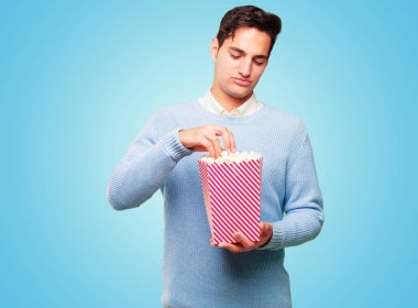 bir pop corn kova ile genç tabaklanmış yakışıklı