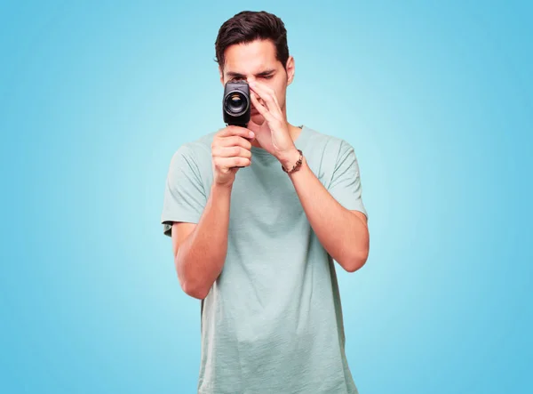 young handsome tanned man with a vintage cinema camera