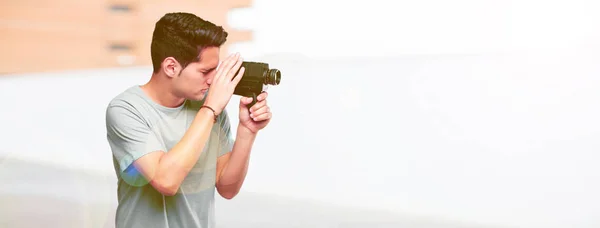 young handsome tanned man with a vintage cinema camera