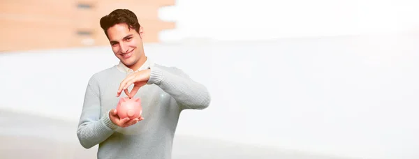 Young Handsome Tanned Man Piggy Bank — Stock Photo, Image