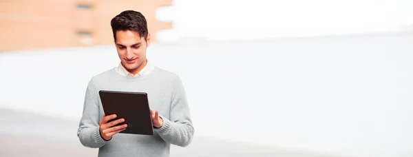 young handsome tanned man with a touch screen tablet