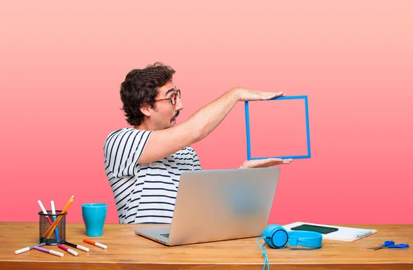 Junger Verrückter Grafikdesigner Auf Einem Schreibtisch Mit Laptop Und Rahmen — Stockfoto