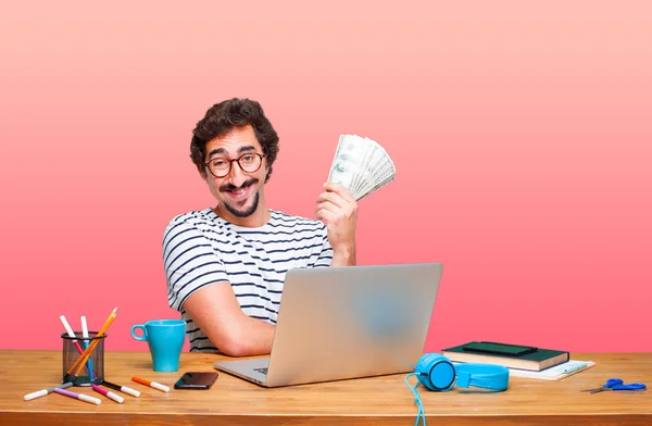 young crazy graphic designer on a desk with a laptop and pay, buying or money concept