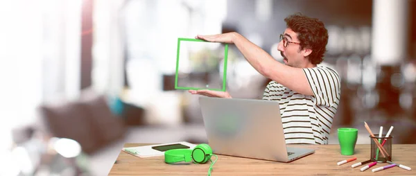 Junger Verrückter Grafikdesigner Auf Einem Schreibtisch Mit Laptop Und Rahmen — Stockfoto