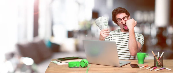 young crazy graphic designer on a desk with a laptop and pay, buying or money concept