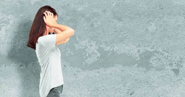 Genç kız tam vücut onları yüksek sesle, bir rahatsız korumak için kulaklar kapsayan iki elinle gürültü rahatsız edici güzel. Yanal veya yan görünüm.