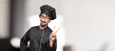 Genç adam şef gurur, mutlu ve kendine güvenen bir ifade ile; gülümseyen ve zafer kutluyor bir 