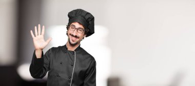 Beş parmaklı, avuç ile sayılması gülümseyen ve memnun ve mutlu, arayan genç adam şef.