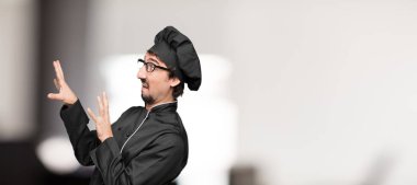 Genç adam aşçı arayanlar korkmuş ve dehşete, korkuyor, dehşet içinde çığlık, kıyamet günü karşı karşıya, çok korkmuş hissediyor. Yanal veya yan görünüm.