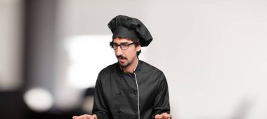 Genç adam şefle öfkeyle ve kati yumruk gösteren bir öfkeli, agresif ve tehditkar poz, dövüş için hazır.