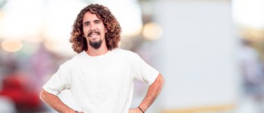 Genç hipster adam yan, gurur, memnun ayakta ve mutlu yüzündeki ifade, silah ile gülümseyen geçti. Yan veya yan görünüm.