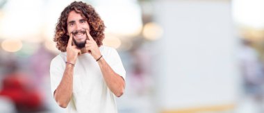 sessizlik isteyen ya da bir sırrı tutmak, ağız, önünde işaret parmağı ile gülümseyen genç hipster adam