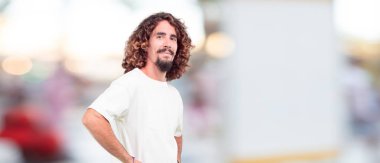 yana doğru ayakta, gülümseyen, mutlu ve sevgi arıyorum, bir kalp el ile şekil verme genç hipster adam. Yan veya yan görünüm.