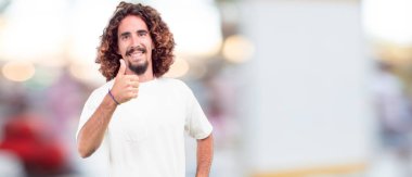 gülümseyen ve yukarı doğru nerede gazeteci bir kavram gösterebilir miyim yere doğru iki eliyle işaret eden genç hipster adam.