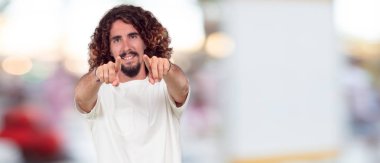 Genç hipster Concentrating sert bir fikirle ciddi bir uzak göz önünde çapraz kol ile düşünme dostum ve alnına işaret parmak Dizin.