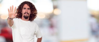 Genç hipster adam iki eliyle önünde ağız sessiz kalma ve gizli tutmak için geçti.