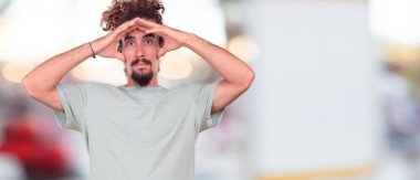 Genç hipster adamla şokta iki elinizle alın ve ağız geniş açık tutan bir sürpriz, hayret ifade.