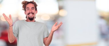 mutlu bir adamla genç hipster ifade şaşırttı, gözleri geniş açık ve geniş gülümseme, yüz iki eliyle tutarak.