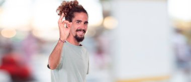 gururla gülümsüyor ve güvenle kalça akimbo poz, mutlu ve başarı, emin ellerde silah ile bir 